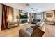 Cozy living room with a large leather sofa, modern fireplace, and a large TV at 41143 W Rio Bravo Dr, Maricopa, AZ 85138
