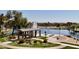 Beautiful park featuring a covered picnic area, lush greenery, and a tranquil lake in the background at 41143 W Rio Bravo Dr, Maricopa, AZ 85138