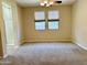 Serene main bedroom with carpet flooring and two windows, adjacent to the ensuite bathroom at 4117 W Allen St, Laveen, AZ 85339