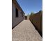 View down the side yard which features rock ground cover and block fence at 4117 W Allen St, Laveen, AZ 85339