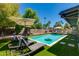 Lounge chairs surrounding a backyard pool with artificial turf and palm trees in the background at 4932 E Kathleen Rd, Scottsdale, AZ 85254