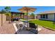Inviting backyard oasis featuring a dining area, pergola, artificial grass, and mature landscaping at 4932 E Kathleen Rd, Scottsdale, AZ 85254
