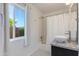 Bright bathroom features a single sink, granite countertops, tiled shower, and a view to backyard at 4932 E Kathleen Rd, Scottsdale, AZ 85254