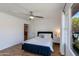 Cozy bedroom with a ceiling fan, large window with pool view, and a stylish bed with decorative pillows at 4932 E Kathleen Rd, Scottsdale, AZ 85254