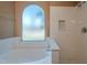 Bright bathroom features a soaking tub and tiled shower with niche at 5952 E Phelps Rd, Scottsdale, AZ 85254