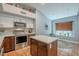 Well-lit kitchen featuring stainless steel appliances, a kitchen island, and tile flooring at 5952 E Phelps Rd, Scottsdale, AZ 85254