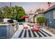 A backyard featuring a built in grill and a glass table with red chairs near the sparkling pool at 6746 E Monterosa St, Scottsdale, AZ 85251
