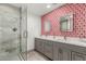 Stylish bathroom featuring a glass-enclosed shower, dual sinks, modern cabinets, and eye-catching patterned wallpaper at 6746 E Monterosa St, Scottsdale, AZ 85251