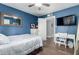 A bedroom with a ceiling fan, a guitar, a television, wood laminate floors, and a white desk at 6746 E Monterosa St, Scottsdale, AZ 85251