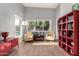 Bright and airy living room with a large window overlooking the pool, cozy chairs, and modern shelving at 6746 E Monterosa St, Scottsdale, AZ 85251