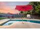 Sparkling swimming pool with lounge chairs, umbrellas, and colorful plants near the backyard fence at 6746 E Monterosa St, Scottsdale, AZ 85251