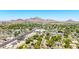 Expansive aerial view showcasing a vibrant neighborhood nestled against a backdrop of majestic mountains under a clear blue sky at 6819 N 10Th Pl, Phoenix, AZ 85014