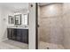 Bathroom featuring double sinks, granite countertops, and a walk-in shower with a mosaic tile floor at 6819 N 10Th Pl, Phoenix, AZ 85014