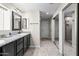 Bathroom featuring double sinks, granite countertops, and a walk-in shower with a glass door at 6819 N 10Th Pl, Phoenix, AZ 85014