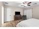 This bedroom has wood-look floors, a ceiling fan, and a full-length window with white curtains at 6819 N 10Th Pl, Phoenix, AZ 85014