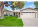 Well-maintained single-story home with a two-car garage and lush green lawn at 6819 N 10Th Pl, Phoenix, AZ 85014