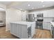 Kitchen features white cabinets, stainless steel appliances, quartz countertops, wine rack, and a kitchen island at 6819 N 10Th Pl, Phoenix, AZ 85014