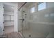 Shower features tiled surround, and glass doors, with a view of the walk-in closet at 7944 W Griswold Rd, Peoria, AZ 85345