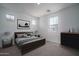 Comfortable bedroom featuring a large bed, soft carpet, and plenty of natural light from three windows at 7944 W Griswold Rd, Peoria, AZ 85345