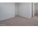 Carpeted bedroom features a white door, baseboards and trim, and open bathroom access at 7944 W Griswold Rd, Peoria, AZ 85345