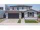 Charming two-story home featuring a gray tiled roof, brick driveway, and a neatly manicured lawn at 7944 W Griswold Rd, Peoria, AZ 85345
