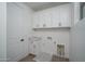 The laundry room features white cabinets with modern fixtures and a utility sink at 7944 W Griswold Rd, Peoria, AZ 85345