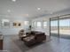 Bright living room with a leather sectional, modern decor, and sliding glass doors at 7944 W Griswold Rd, Peoria, AZ 85345