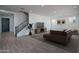 Open-concept living room features modern staircase, large TV, and stylish furniture at 7944 W Griswold Rd, Peoria, AZ 85345