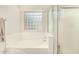 Clean, well-lit bathroom with a bathtub, shower, and a window block accent at 80 W Grey Stone St, San Tan Valley, AZ 85143