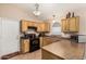 Functional kitchen with wooden cabinetry, modern appliances, and countertops with breakfast bar seating at 80 W Grey Stone St, San Tan Valley, AZ 85143
