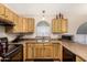 Classic kitchen with wood cabinets, stone countertops, and a stainless steel sink under a window at 80 W Grey Stone St, San Tan Valley, AZ 85143