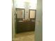 Bathroom featuring a double vanity with dark wood cabinets and dual sinks with framed mirrors at 8700 E Mountain View Rd # 2029, Scottsdale, AZ 85258
