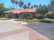 Exterior of the clubhouse with brick accents, a tile roof, and mature landscaping at 8700 E Mountain View Rd # 2029, Scottsdale, AZ 85258