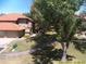 Exterior view of the property showcasing well-maintained lawn, mature tree, and red-tile roofs at 8700 E Mountain View Rd # 2029, Scottsdale, AZ 85258
