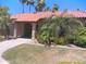 Charming single-story home featuring a red tile roof, lush landscaping, and mature palm trees at 8700 E Mountain View Rd # 2029, Scottsdale, AZ 85258
