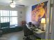 Well-lit home office featuring a large window, ceiling fan, desk setup, and unique octopus artwork at 8700 E Mountain View Rd # 2029, Scottsdale, AZ 85258