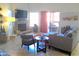 Cozy living room featuring a stone fireplace, plush seating, and bright windows for natural light at 8700 E Mountain View Rd # 2029, Scottsdale, AZ 85258