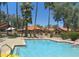 Community pool area with lounge chairs, dining table, and lush landscaping for relaxation at 8700 E Mountain View Rd # 2029, Scottsdale, AZ 85258