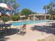 Community pool featuring patio furniture, lounge chairs, and shaded seating areas at 8700 E Mountain View Rd # 2029, Scottsdale, AZ 85258