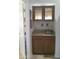 Cozy wet bar with granite countertop, wooden cabinetry, glass storage, and a stainless steel sink at 8700 E Mountain View Rd # 2029, Scottsdale, AZ 85258