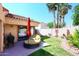 Serene backyard oasis with lush green lawn, cozy daybed, mature landscaping, and a red umbrella at 9115 N 101St Way, Scottsdale, AZ 85258