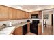 Charming kitchen features granite countertops, oak cabinets, and black appliances at 9115 N 101St Way, Scottsdale, AZ 85258