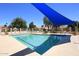 Community pool surrounded by lounge chairs, shade structure, and well-maintained landscaping at 9115 N 101St Way, Scottsdale, AZ 85258