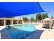 Sparkling community pool area with a shade structure, lounge chairs, and beautiful desert landscaping at 9115 N 101St Way, Scottsdale, AZ 85258