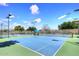 A well-maintained tennis court with blue and green surface, under a sunny sky at 9115 N 101St Way, Scottsdale, AZ 85258