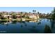 Beautiful waterfront homes reflecting on the community lake, lined with lush palm trees at 9115 N 101St Way, Scottsdale, AZ 85258