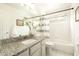 Bright bathroom with granite vanity, shower-tub combo, and tiled floors at 9224 E Windrose Dr, Scottsdale, AZ 85260