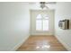 Bright bedroom featuring wood floors, a window, and an air conditioning unit at 9224 E Windrose Dr, Scottsdale, AZ 85260