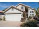 A well-maintained house with mature landscaping, arched window, and three car garage at 9224 E Windrose Dr, Scottsdale, AZ 85260