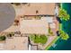 Birds eye view of a home with mature trees and desert landscaping overlooking a lake at 10526 W Tonopah Dr, Peoria, AZ 85382